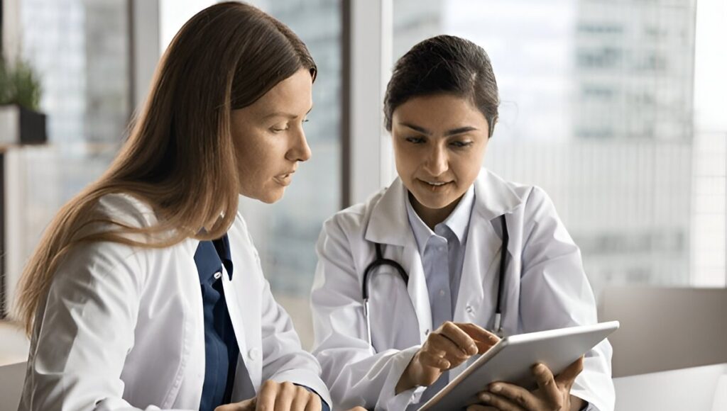Doctors discussing medical admission guidance using tablet in office setting
